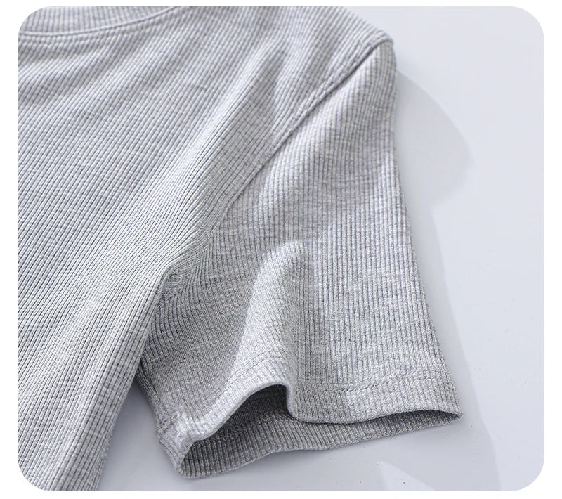 Close-up of a light grey ribbed short-sleeved t-shirt showing the textured fabric and stitched sleeve detail.