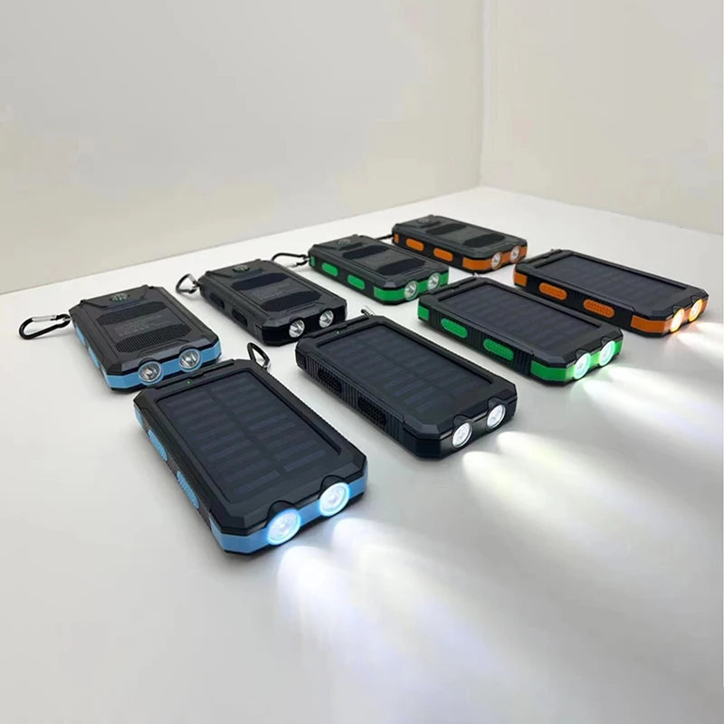 A group of rugged solar power banks in blue, green, and orange, featuring built-in LED torches and carabiner clips.