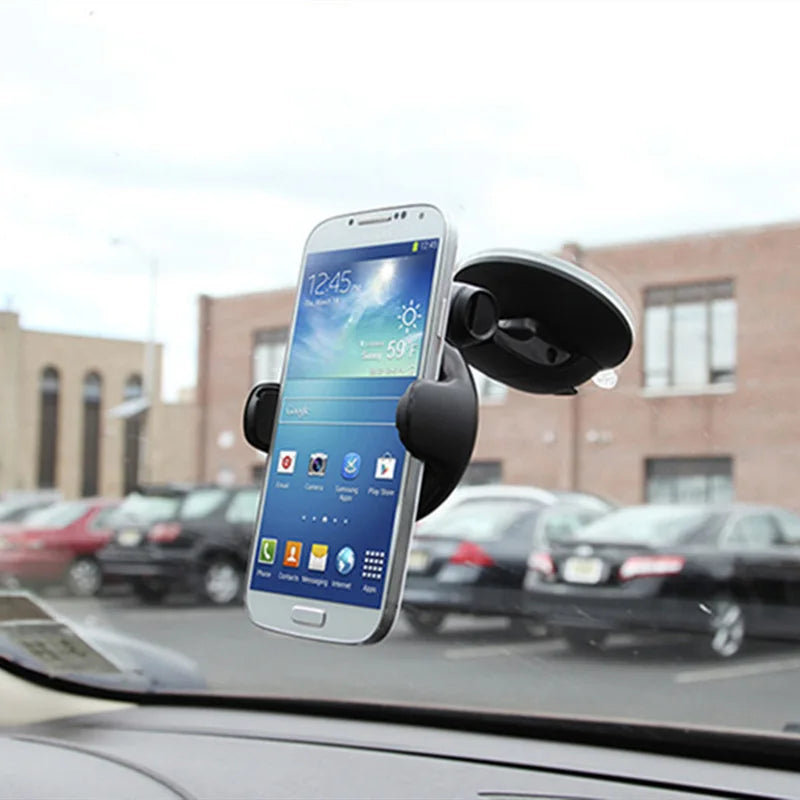 Black car phone mount with a suction cup attachment, holding a smartphone securely on a vehicle windscreen.