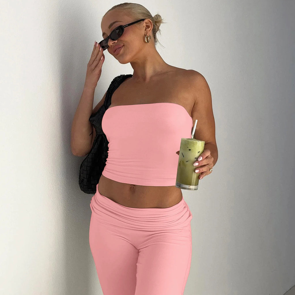 Woman wearing a baby pink strapless crop top and matching high-waisted leggings with a folded waistband.