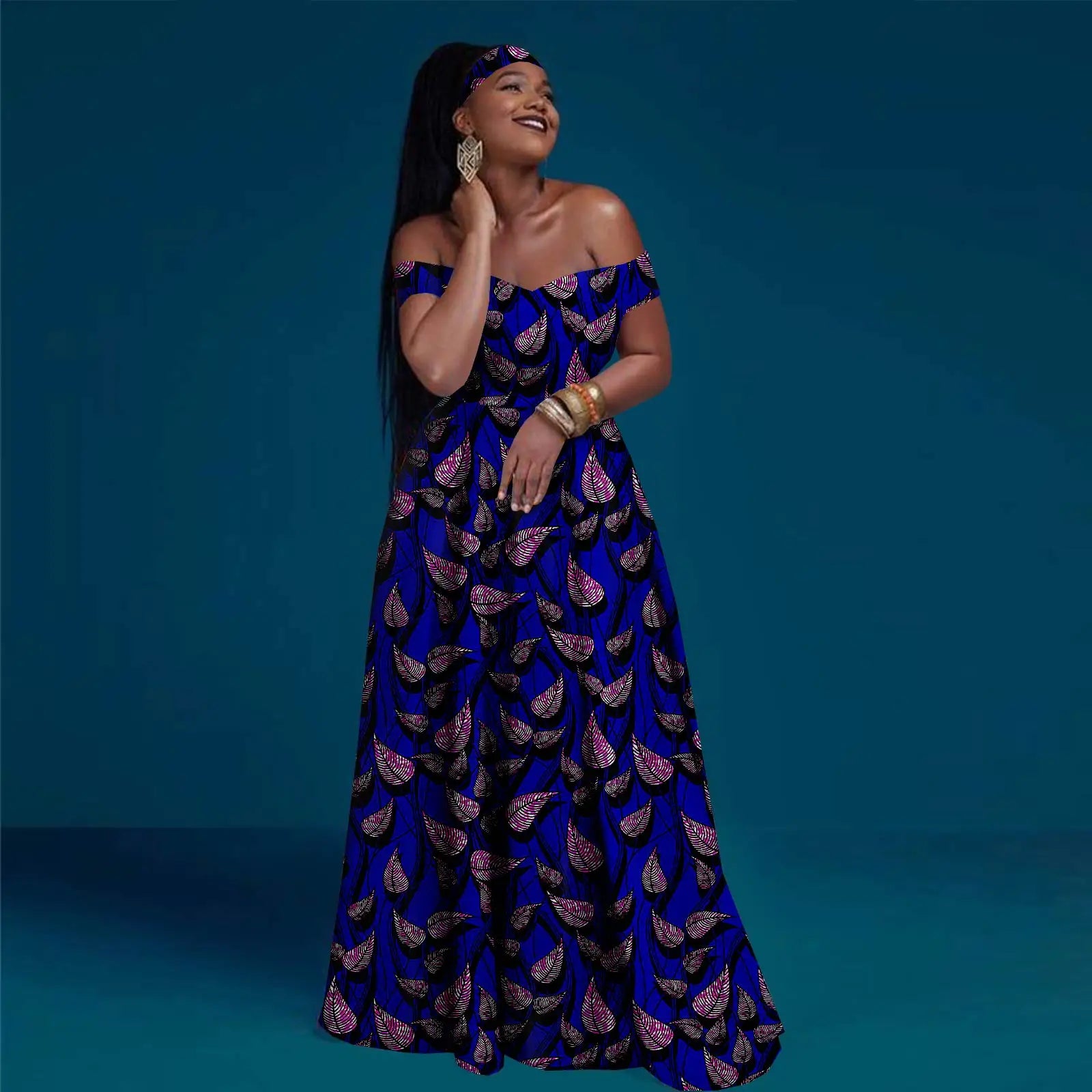 Model wearing a blue, off-shoulder maxi dress with a purple and black leaf pattern and matching headband.