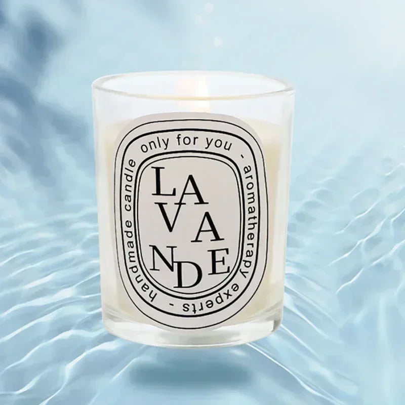 Lit lavender-scented aromatherapy candle in a clear glass votive with a decorative white oval label.