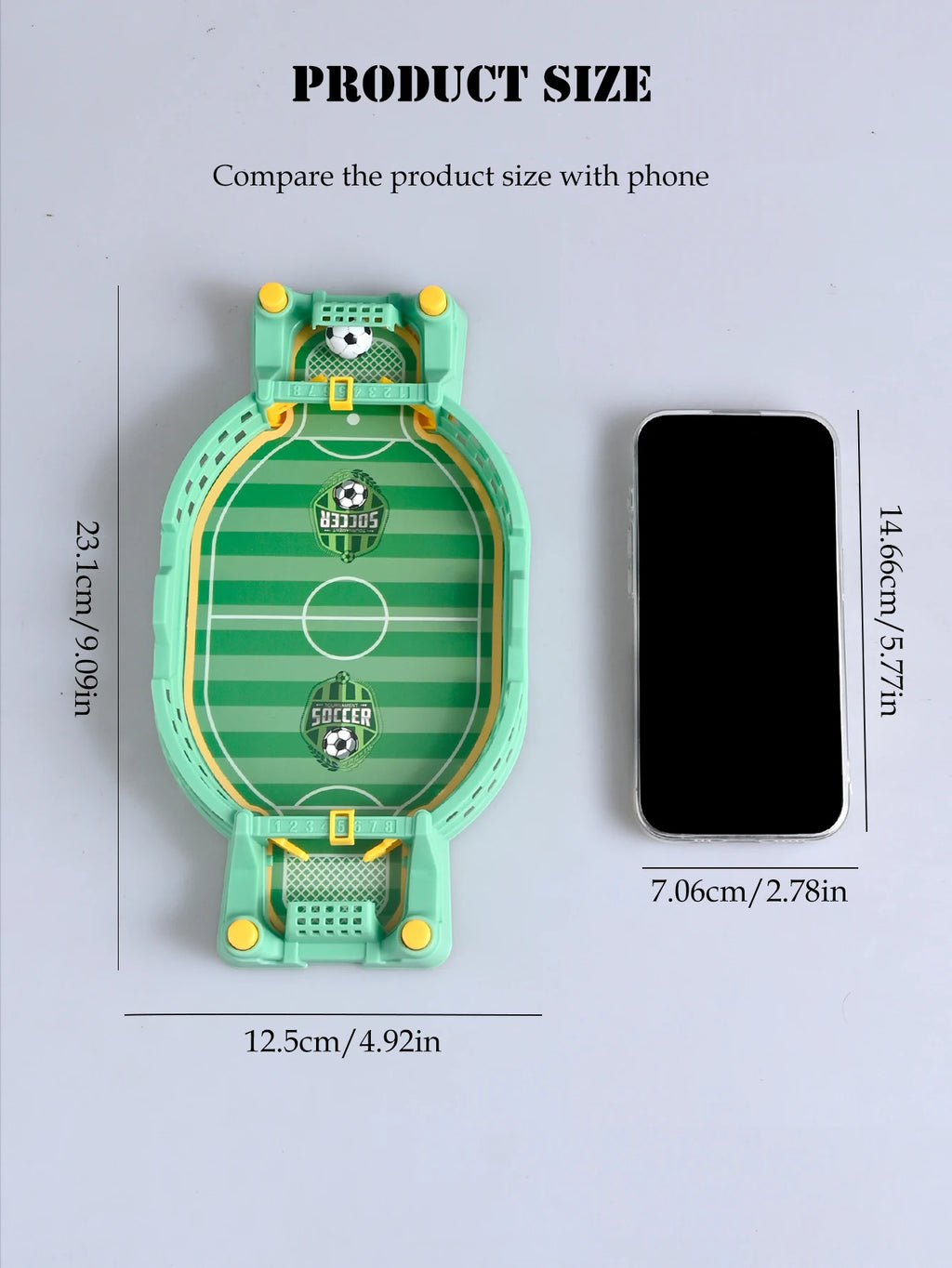 Small green and yellow tabletop football game with a mini pitch, goals, and ball, shown next to a smartphone for scale.