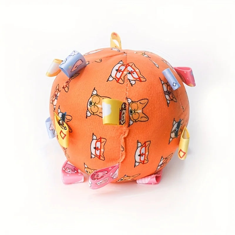 Orange fleece dog ball featuring cartoon animal patterns with colourful fabric ribbon loops for interactive play.
