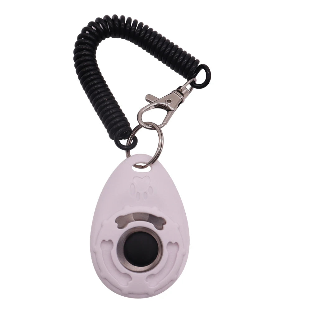 White dog training clicker with a black button, featuring a paw print design, metal keyring and black coil wrist strap.