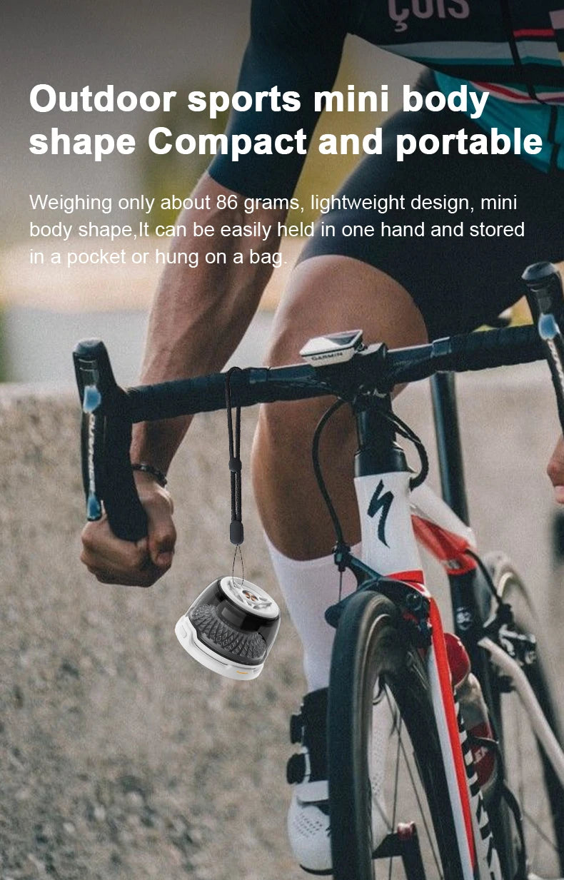 A small, white and grey portable Bluetooth speaker with a lanyard, hanging from a road bike handlebar.