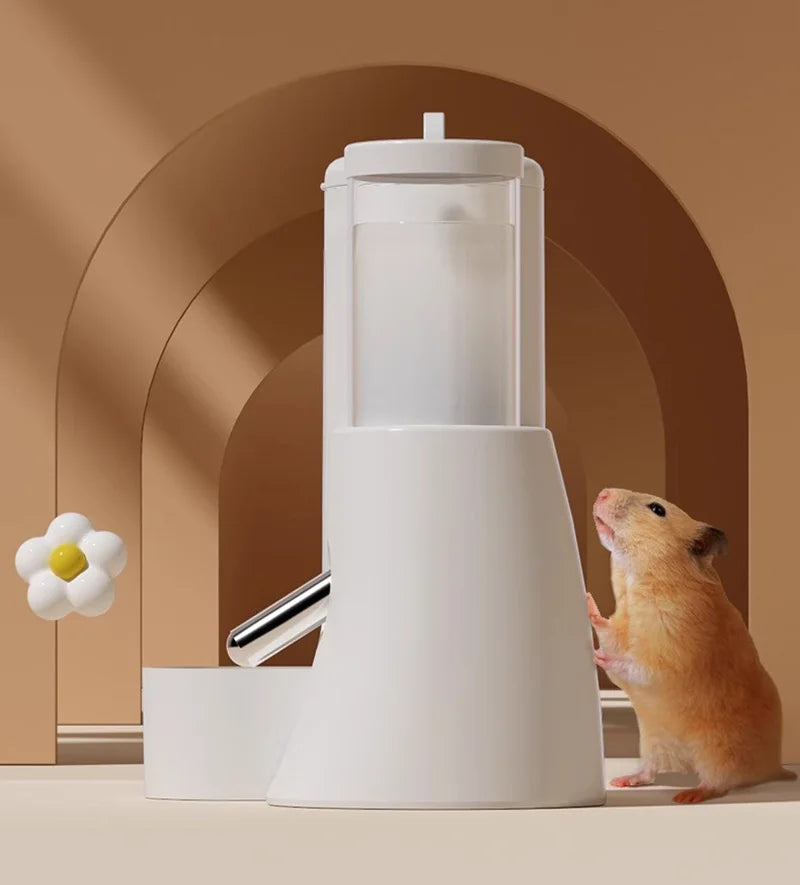Small hamster next to a minimalist white water dispenser with a clear tank and stainless steel nozzle.