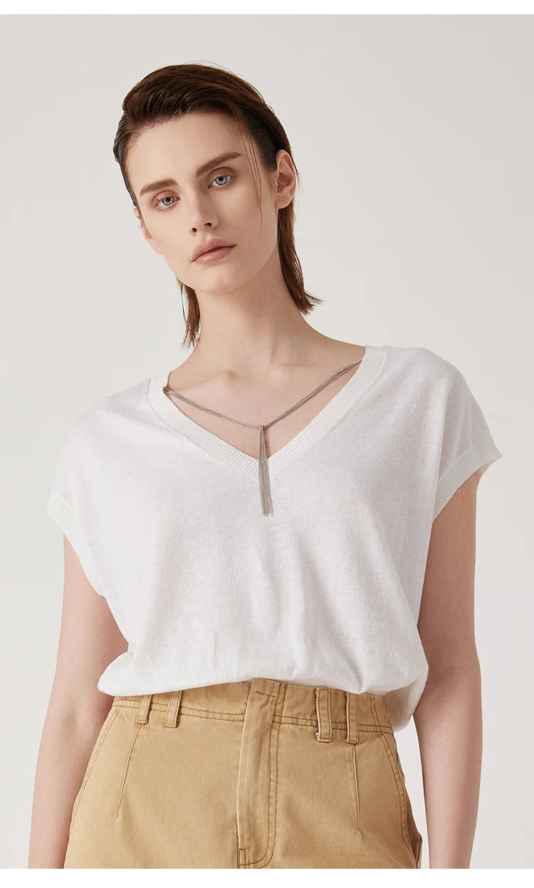 White V-neck knitted top with short sleeves and a delicate silver chain detail at the neckline.