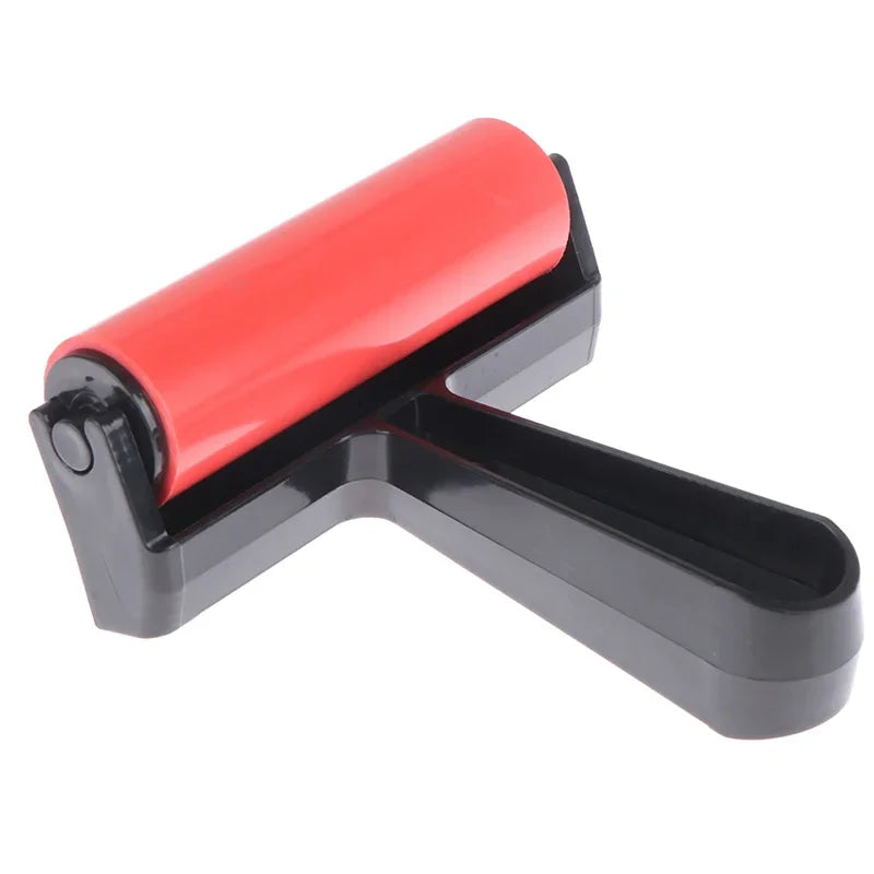 Craft roller with a bright red rubber barrel and a sturdy black plastic handle.