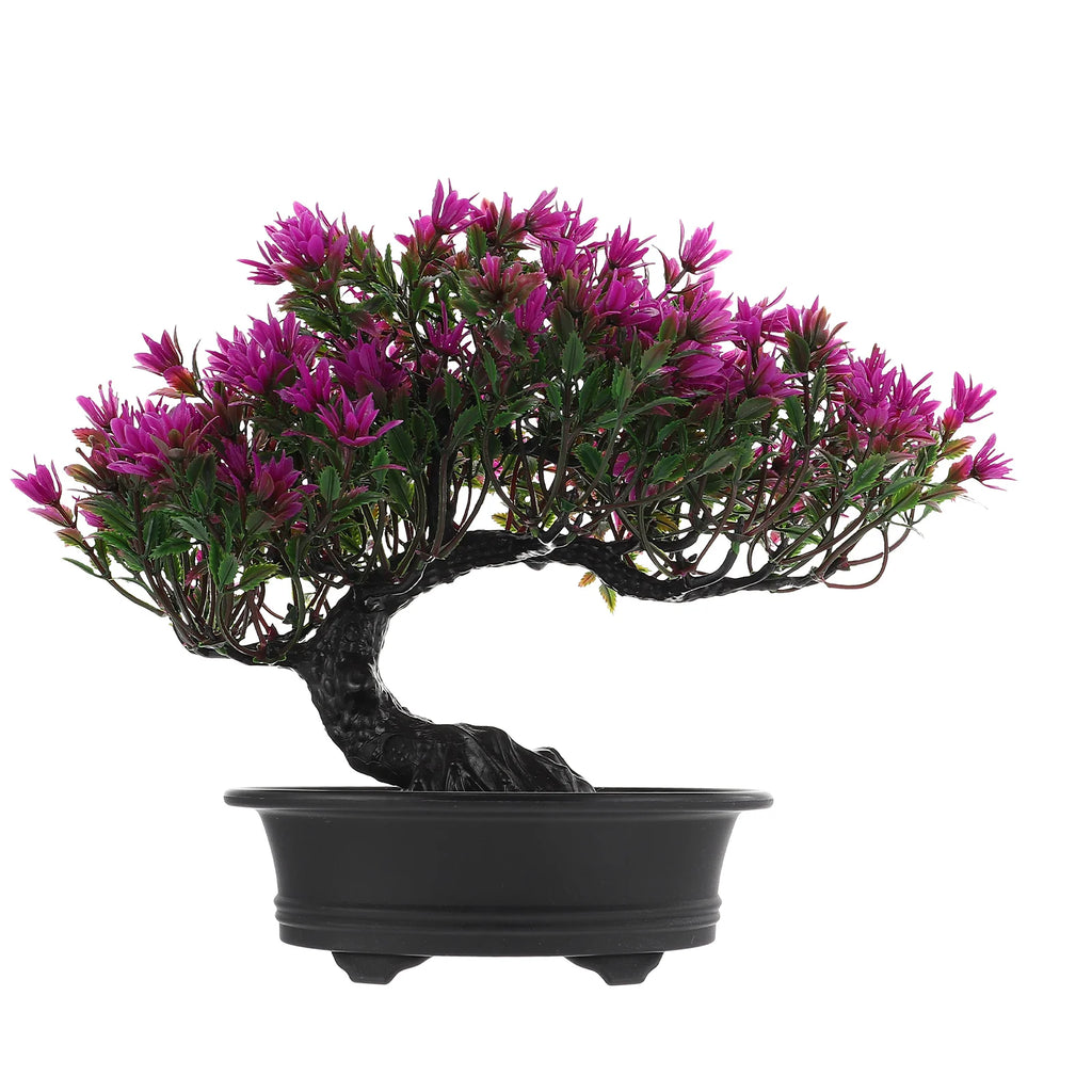 Artificial bonsai tree with vibrant purple flowers and green leaves in a simple black, footed plastic pot.