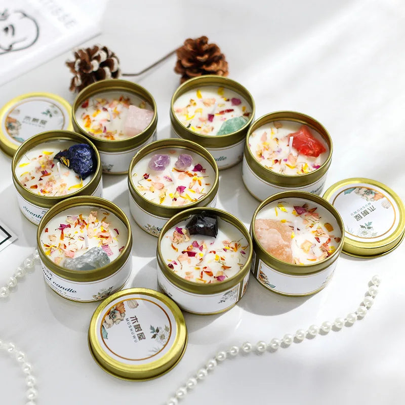 Set of round gold-tone candles infused with dried flower petals and assorted raw crystals in white wax.
