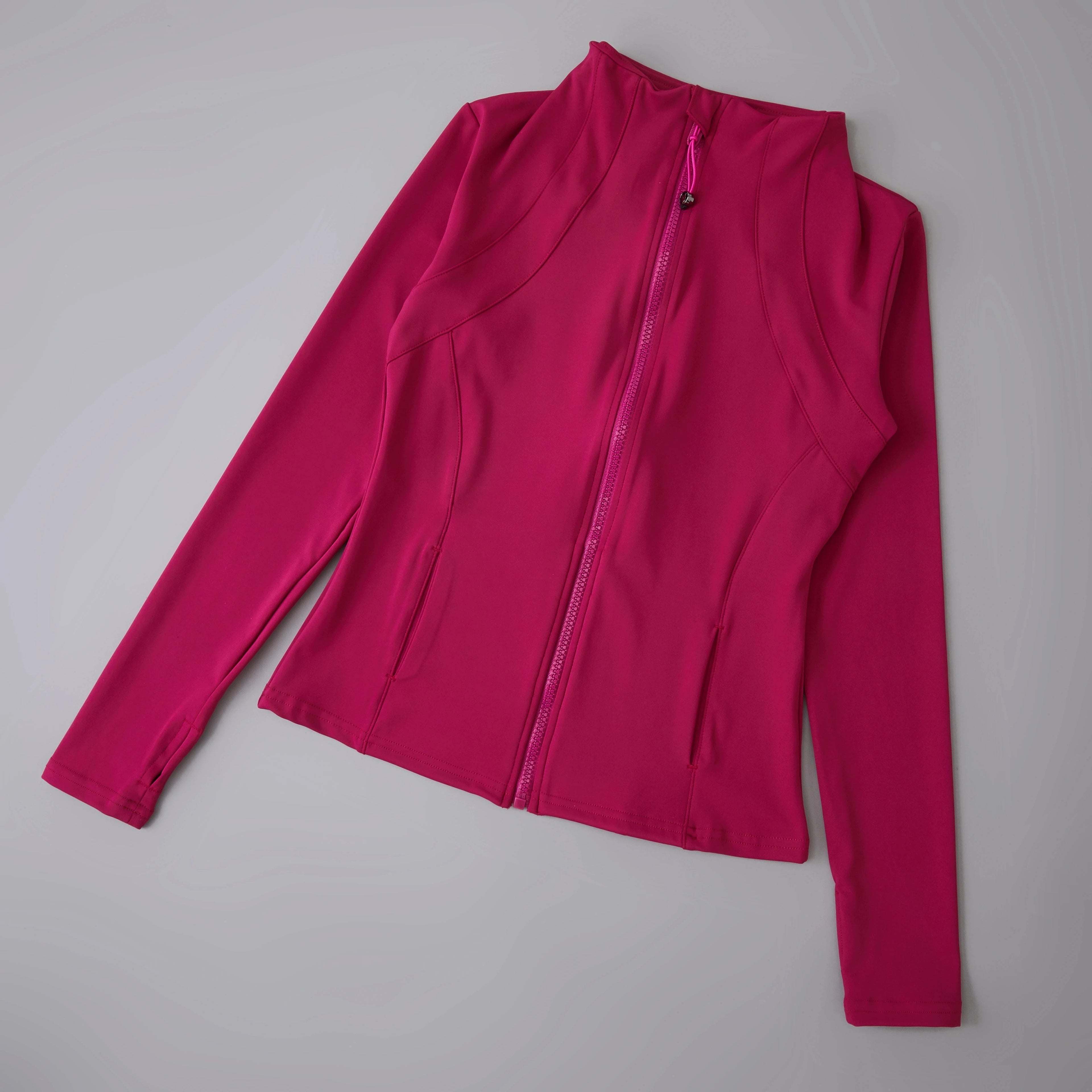 Fuchsia pink long-sleeve sports jacket with a high neck, front zip fastening, and fitted silhouette.