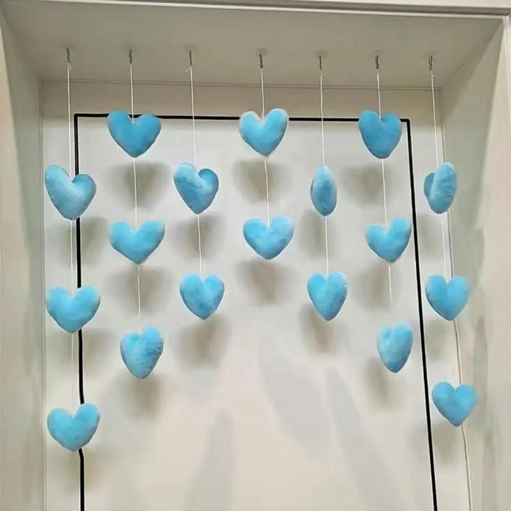 A set of soft, light-blue plush heart ornaments hanging on white strings, perfect for decorative bedroom styling.
