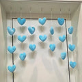 A set of soft, light-blue plush heart ornaments hanging on white strings, perfect for decorative bedroom styling.