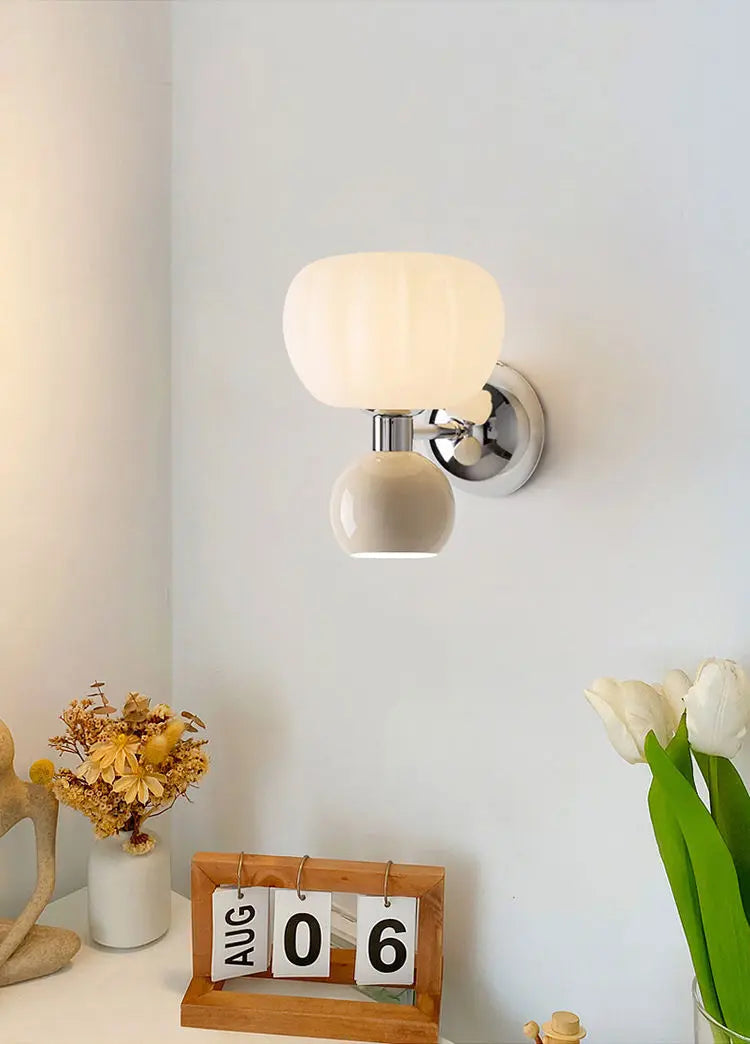 Cream-style wall lamp with a frosted glass mushroom shade, chrome accents, and a rounded cream base.
