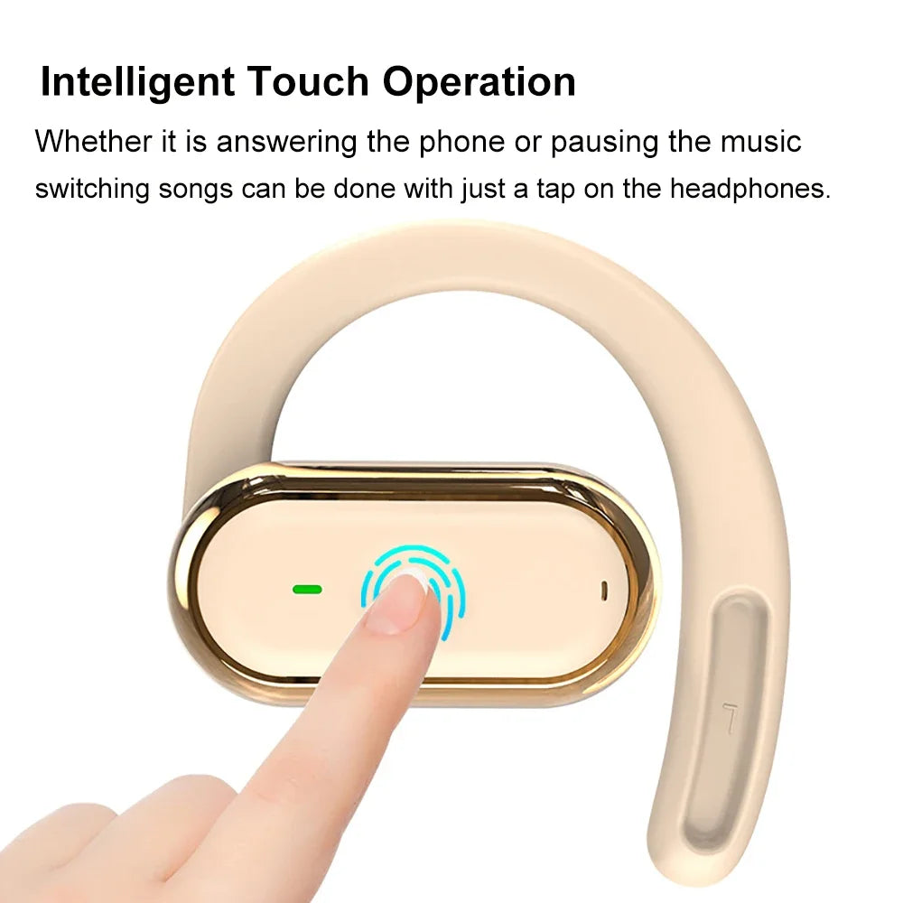 A finger taps the touch-sensitive surface of a beige, wrap-around ear hook headphone with gold metallic trim.