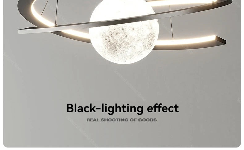 Modern black pendant lamp with an illuminated, textured moon-like central orb and circular LED ring frame.