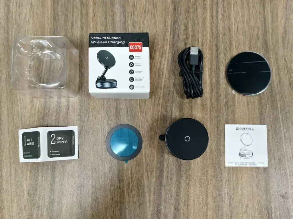 Black vacuum suction wireless charger set with USB cable, adhesive mount, and instruction manual on a wood surface.