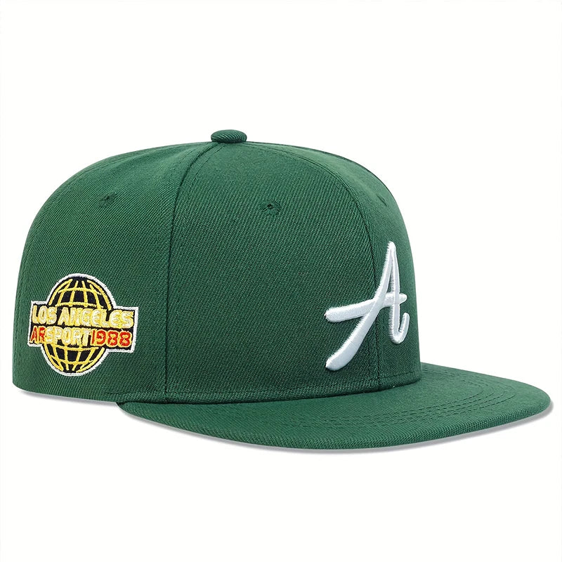 Green unisex baseball cap with a white Gothic letter 'A' on the front and a yellow globe logo on the side.