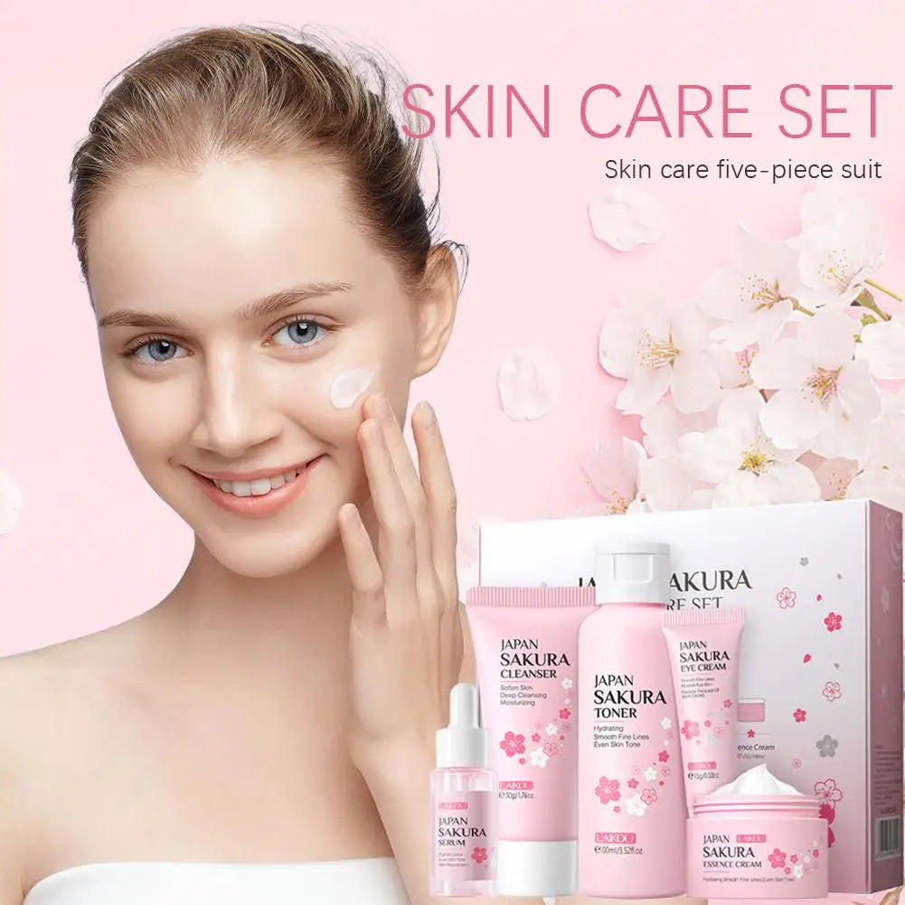 Five-piece pink sakura skincare set, including cleanser, toner, serum, eye cream, and moisturizer in a gift box.