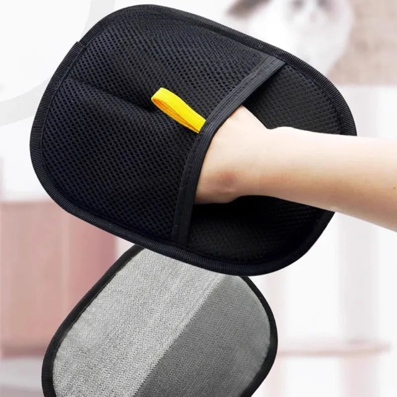 A hand wearing a black mesh cleaning mitt with a yellow hanging loop, next to a grey dual-textured cleaning pad.