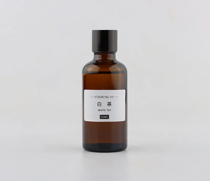 50ml amber glass bottle of White Tea essential oil with a black screw cap and minimalist white label.
