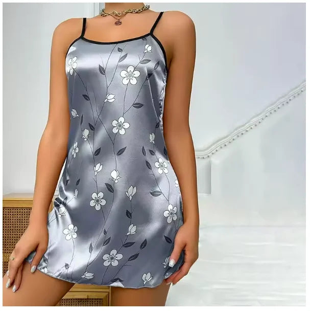 Grey satin mini slip dress with black spaghetti straps and a white floral print.