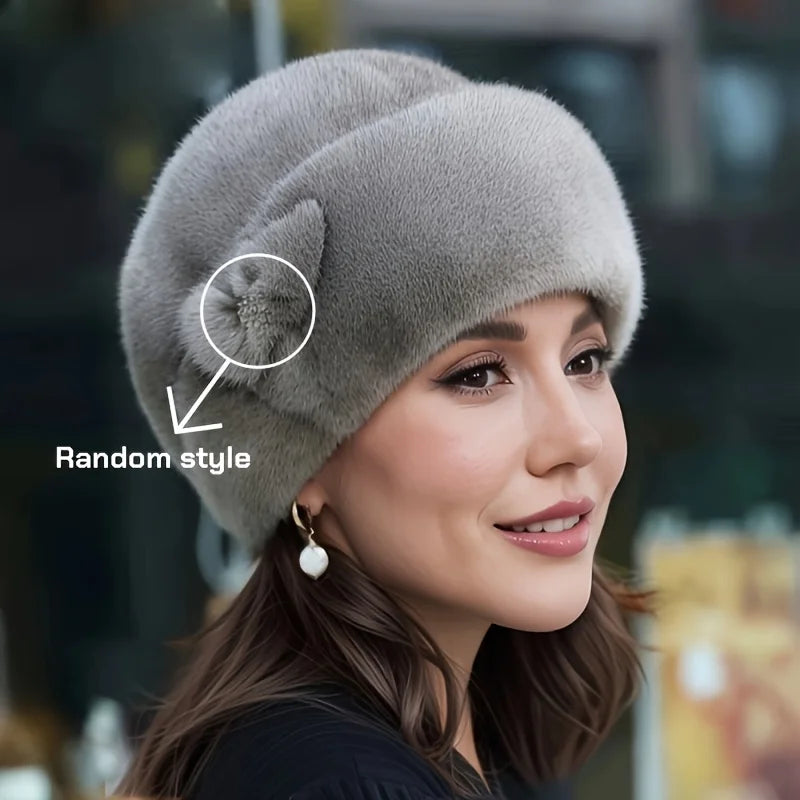 A woman wearing an elegant, grey faux fur winter hat with a decorative side feature.