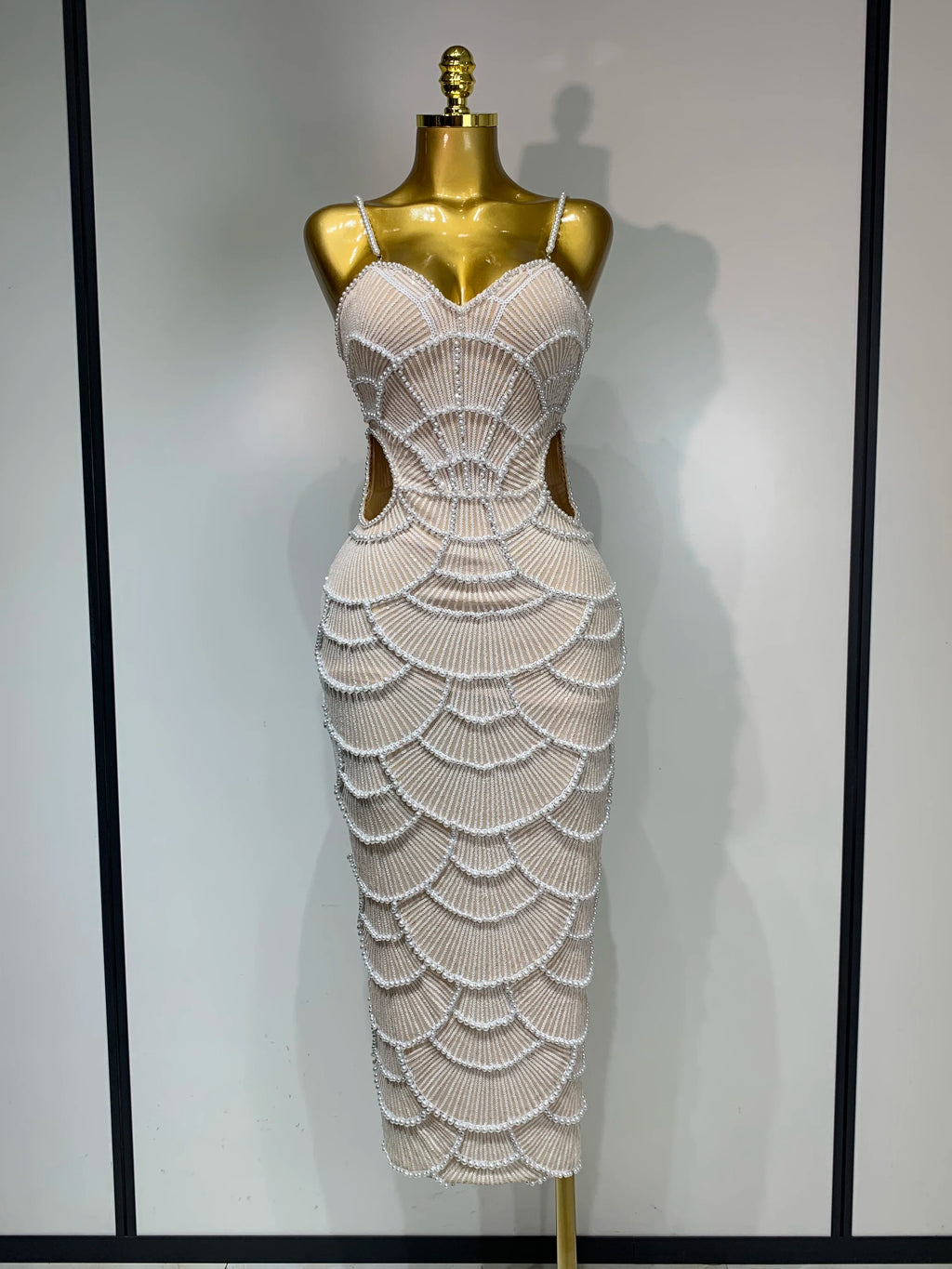 Beige maxi bodycon dress with V-neck, side cut-outs, and intricate pearl beading in scalloped patterns.
