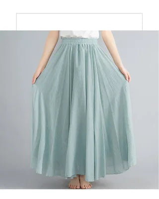 Sage green maxi skirt with an elasticated waistband and a flowing, pleated A-line silhouette.