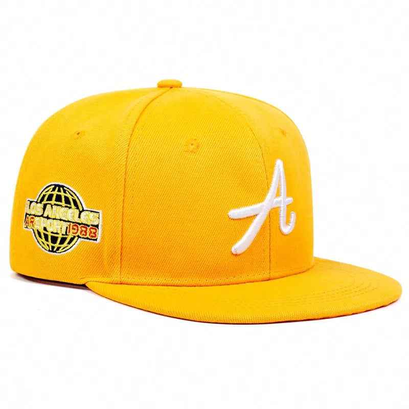 Yellow unisex hip-hop baseball cap with a white embroidered letter 'A' and a globe graphic on the side.