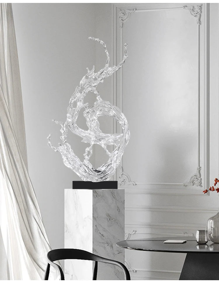 Modern clear resin ornament featuring a dynamic, water-splash design on a black base, displayed on a marble pedestal.