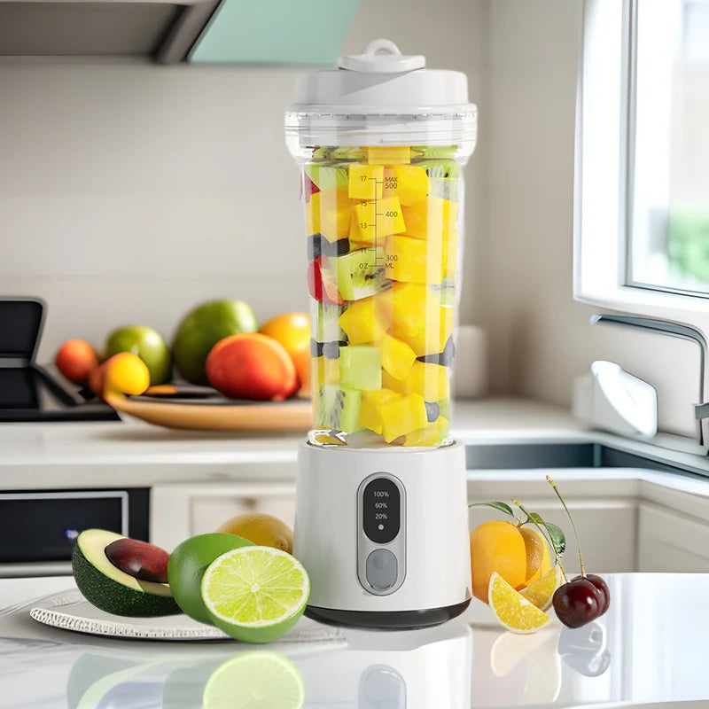 White portable blender filled with chopped fruit, featuring a digital display on the base and a clear, tall cup.