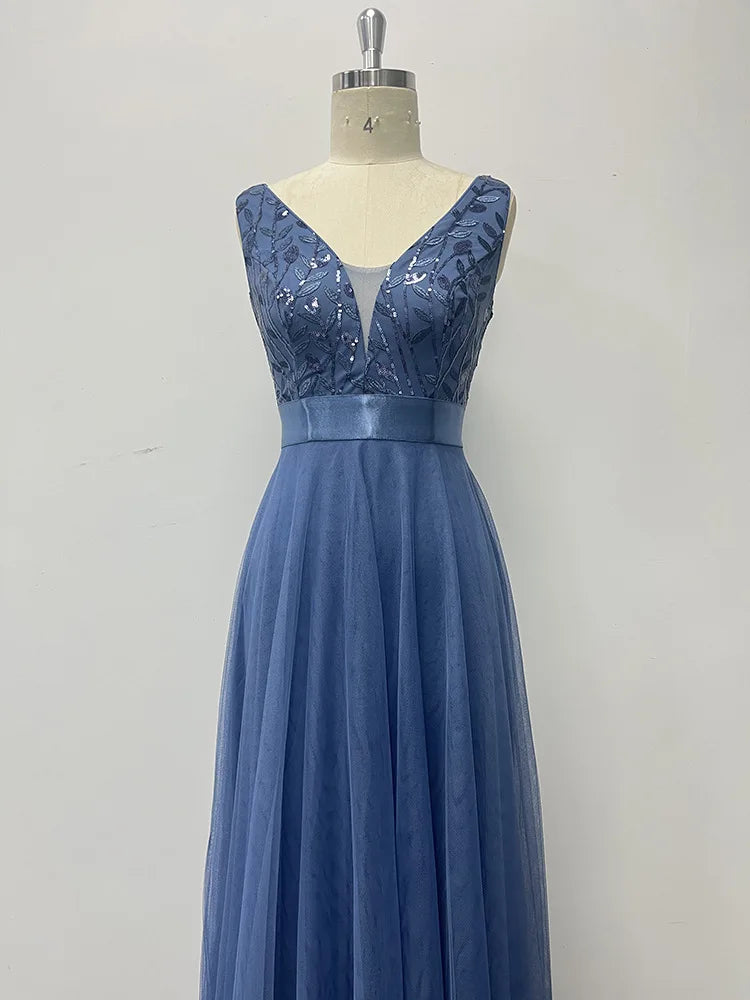 Dusty blue evening dress with a V-neck, sequin bodice, satin waistband, and flowing mesh maxi skirt on a form.