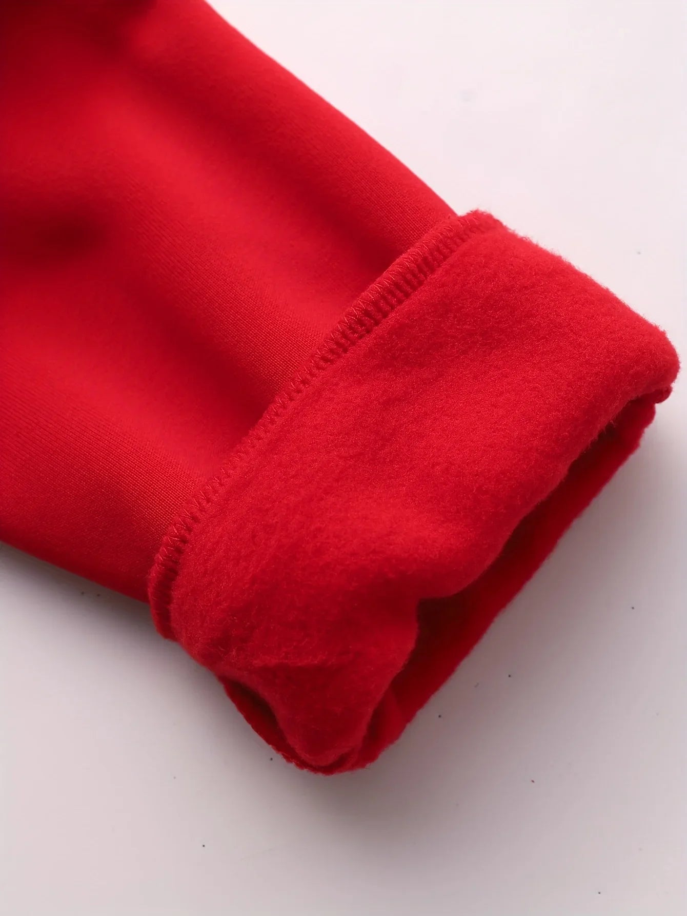Close-up of a bright red sleeve cuff showing a soft, fleece-lined interior.