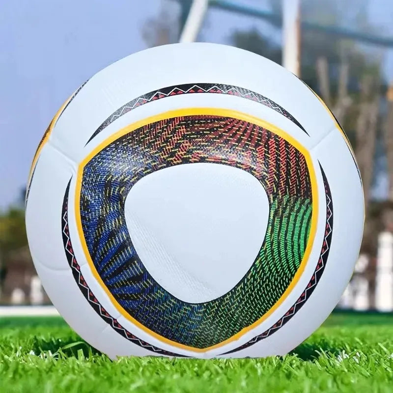 White football with a vibrant, colourful triangular pattern on grass.