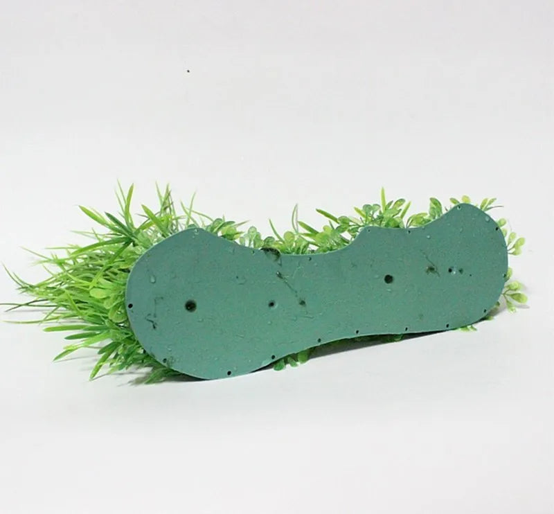 Artificial aquarium grass with a flat, light-green weighted base, shown against a plain white background.