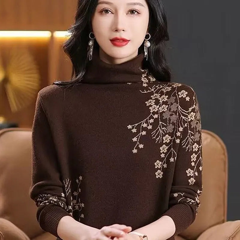 Woman wearing a brown turtleneck sweater with beige floral pattern embroidery on the shoulder and sleeves.