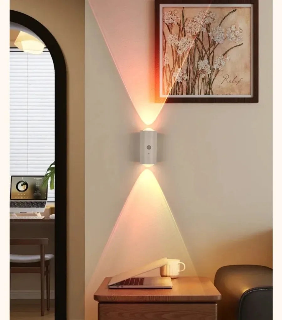Sleek white motion-sensor wall light casting a dual-beam, multicoloured RGB glow in a stylish home interior.
