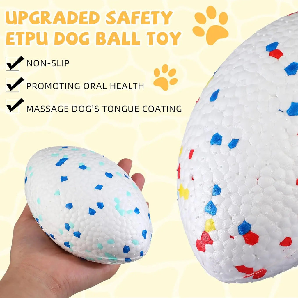 A white, textured, indestructible dog ball with colourful confetti-like speckles, shown being held in a hand.