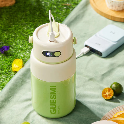 Green 1000ml portable electric blender with a cream-colored top, digital battery display, and charging cable.