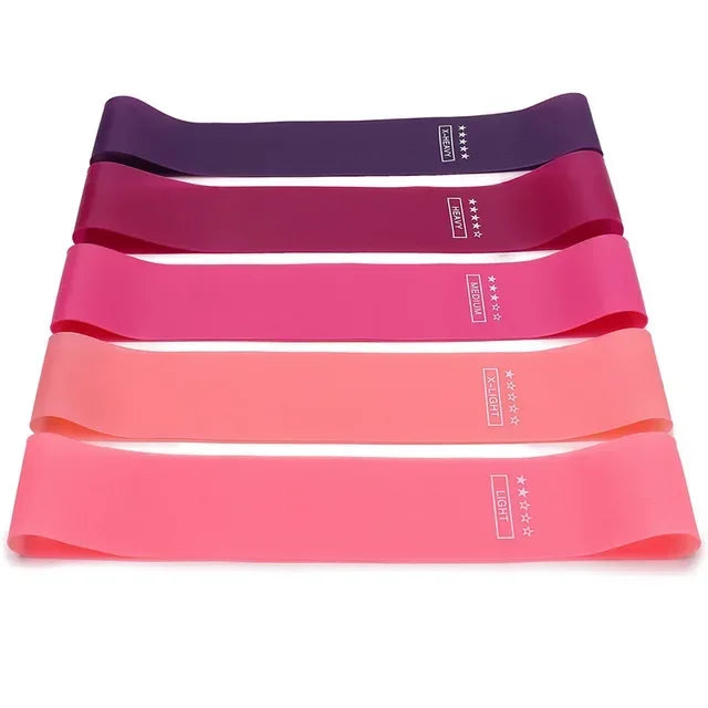Five colourful resistance bands stacked on a white background, ranging from light to extra-heavy intensity.