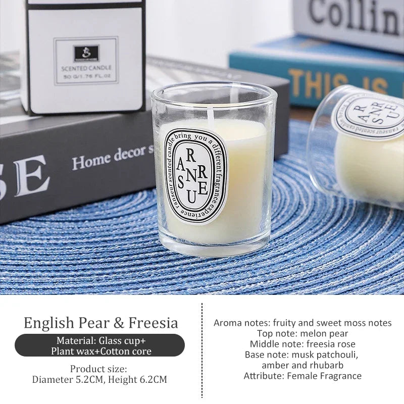 Small ivory scented candle in a clear glass votive with a minimalist label, set on a blue textured mat.