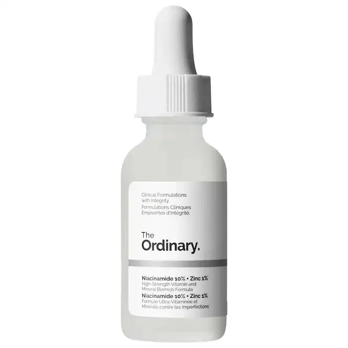Clear glass dropper bottle of Niacinamide 10% + Zinc 1% serum with white cap and clinical label.