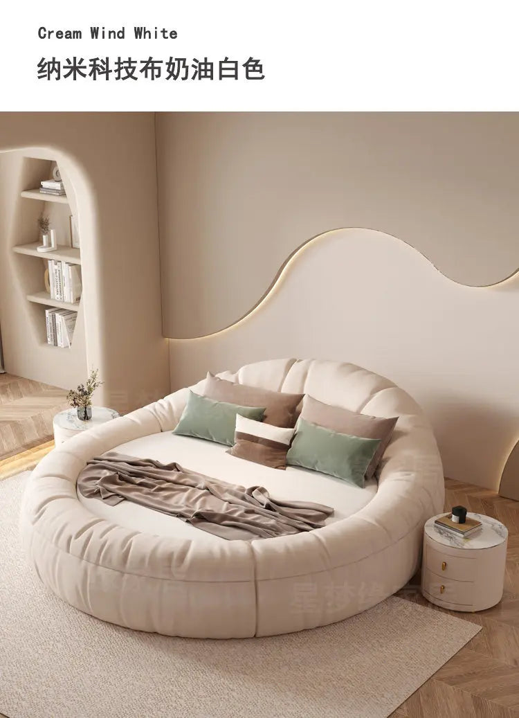 Modern minimalist 200x200cm round bed frame in cream-coloured upholstered fabric, featuring a soft, cushioned surround.