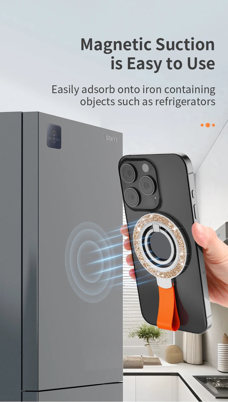 Magnetic phone ring holder with a sparkly gold rim and orange silicone strap, attached to a smartphone on a fridge.