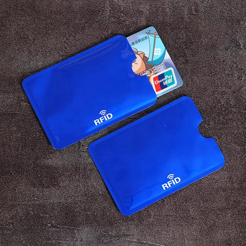 Two blue plastic RFID-blocking card sleeves, one containing a bank card, on a dark textured background.