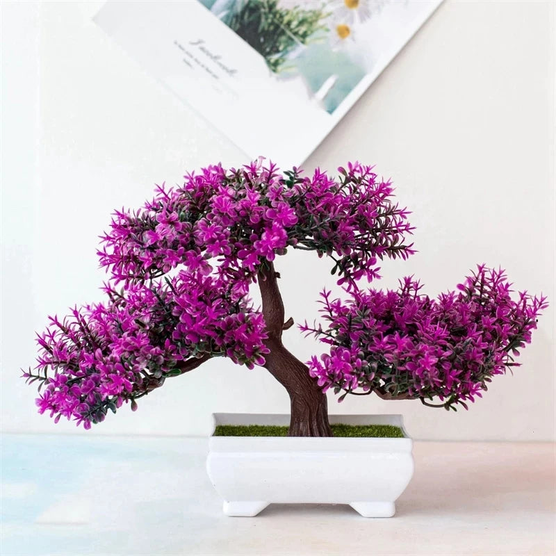 Artificial bonsai tree with vibrant purple foliage in a rectangular white ceramic pot on a white background.