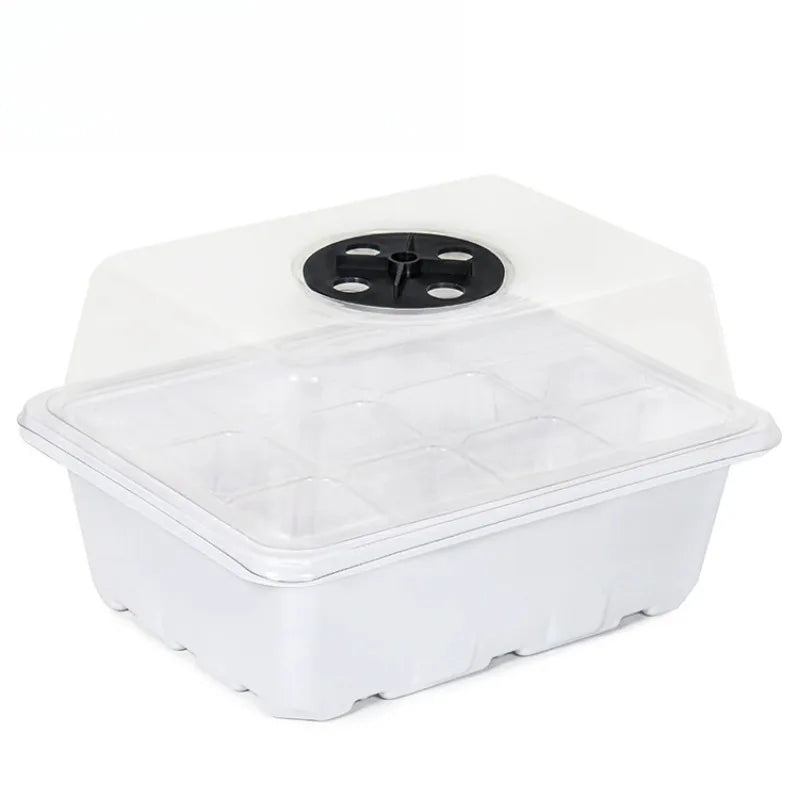 White 12-cell plastic seedling tray with a clear dome lid and a black adjustable ventilation dial on top.