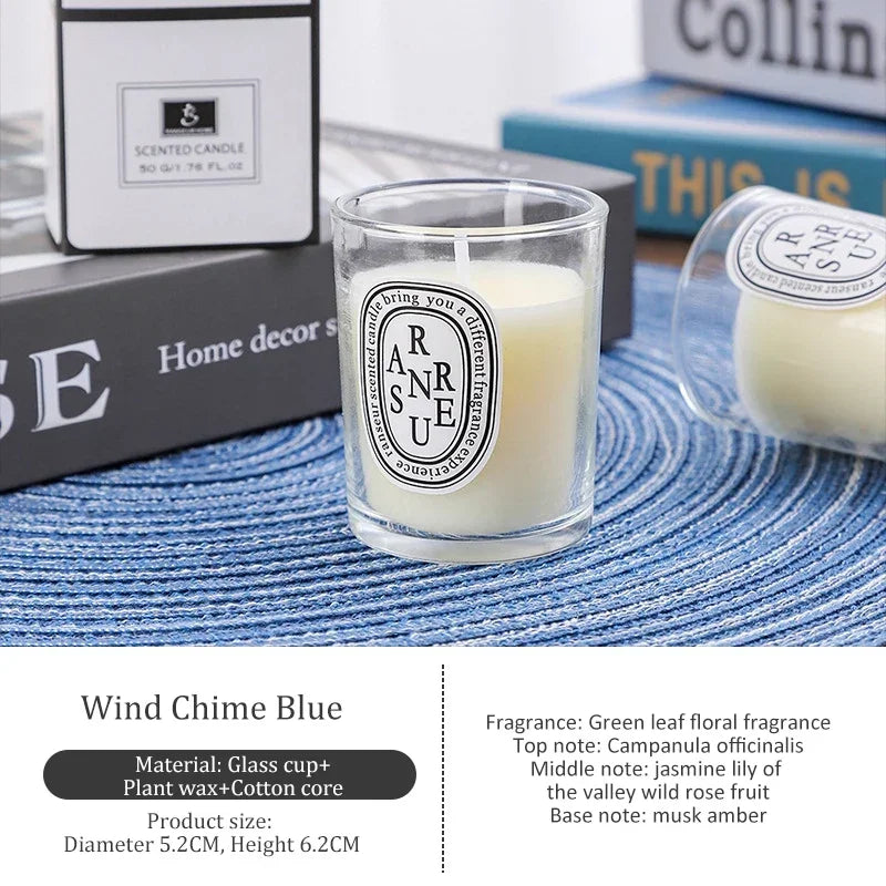 Small cream-coloured scented candle in a clear glass votive with a minimalist label, on a blue textured placemat.